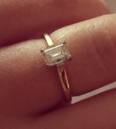 Image of silver ring on a female hand with large square diamond on top