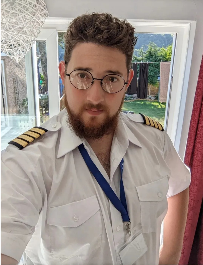 Man with dark hair, glasses and a beard