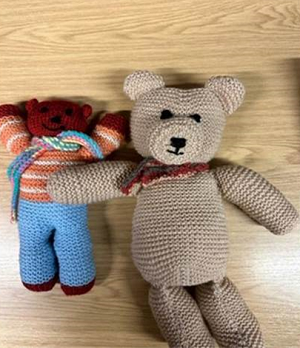 Two teddy bears that have been hand knitted