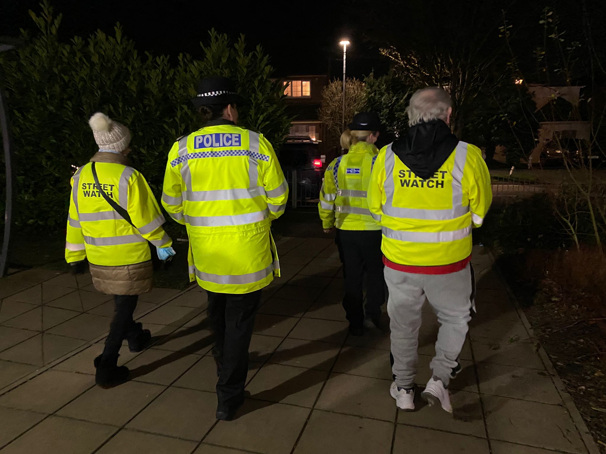 People walking in street wearing high-vis jackets