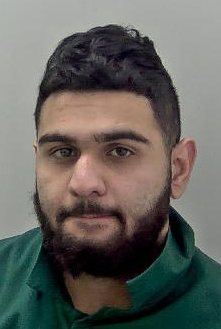 Man with dark hair and full beard and moustache