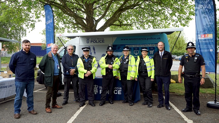 A photo of police officers in front of a business crime police van