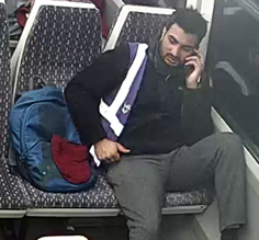 Man with dark hair sat on train