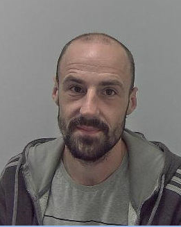 Man with shaven head and short beard
