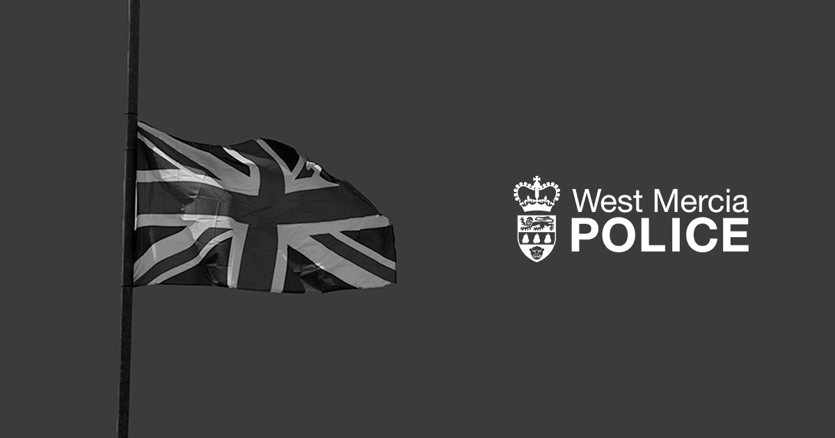 Black and white image shows Union Jack flag flying at half-mast