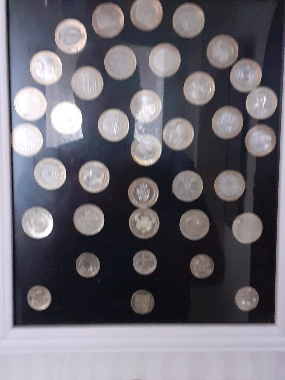 WA2 &ndash; Photograph of the photo frame hung by the front door containing &pound;1 and &pound;2 coins.jpg