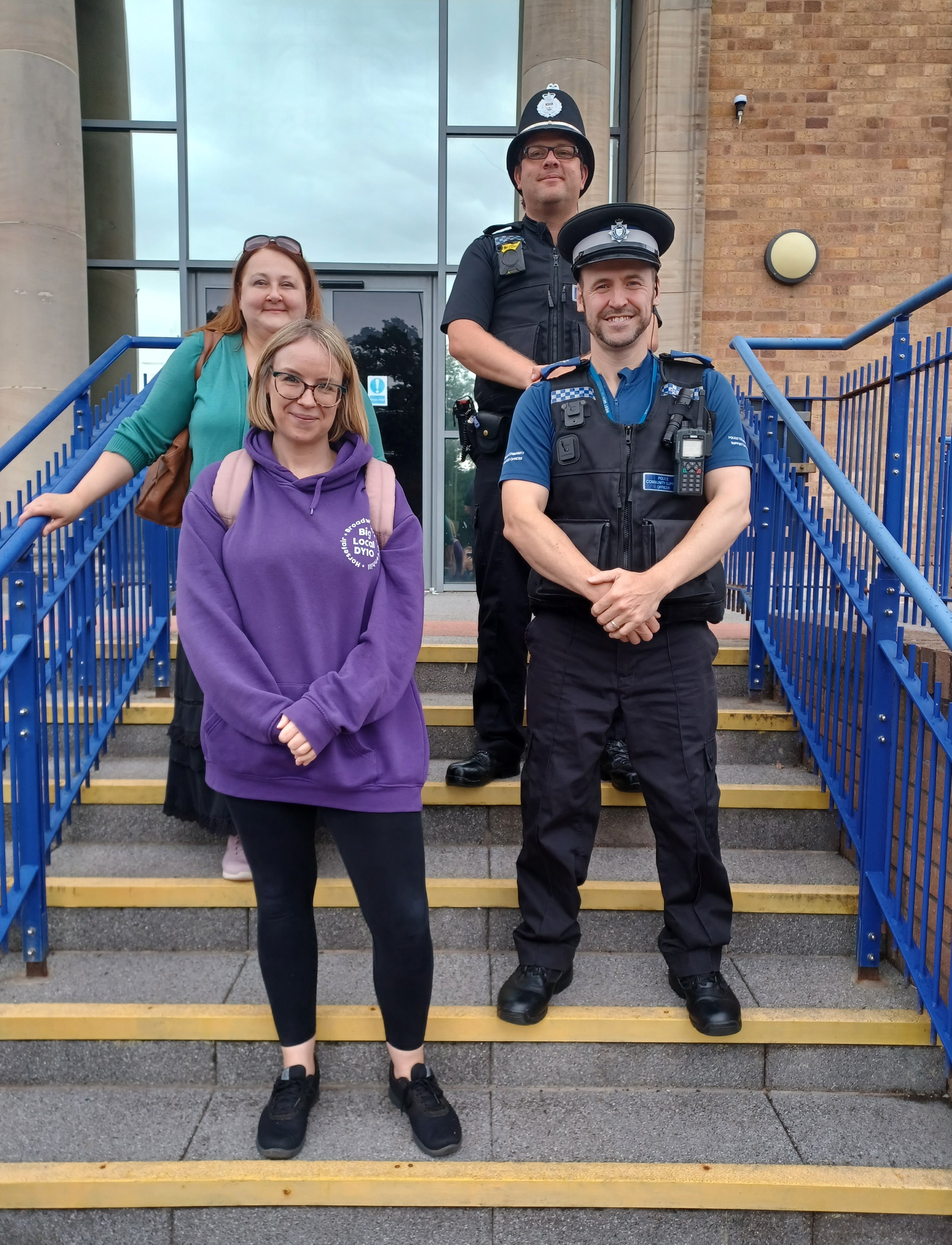 Two women and two officers standing on steps