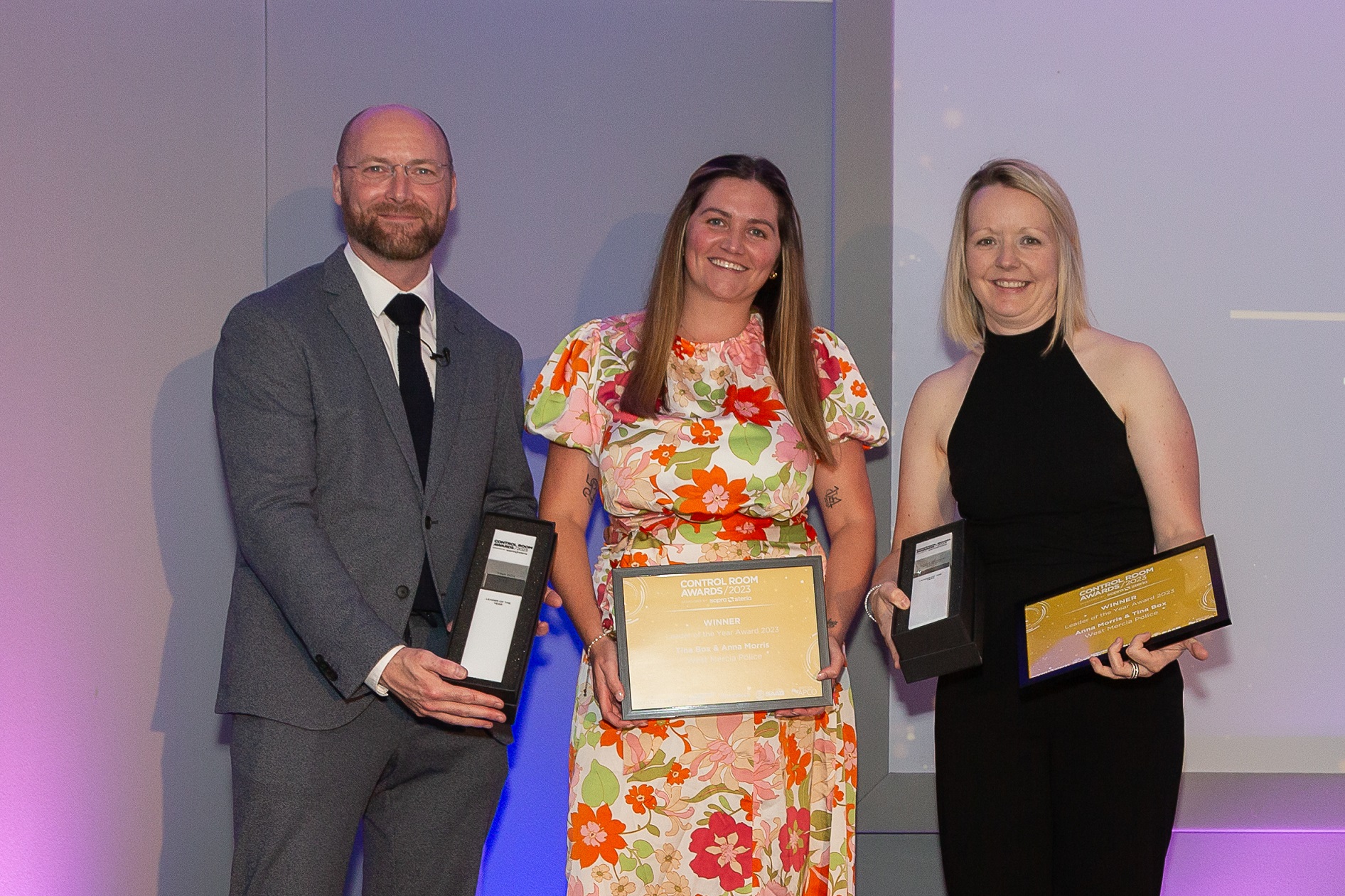 picture of two women and one man holding awards 