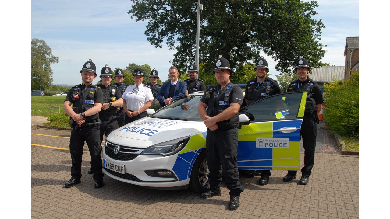 Police officers stood with a patrol vehicle