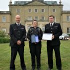 A group of police officers holding a certificate