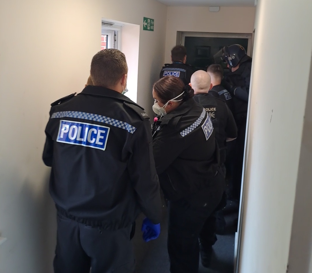Police officers gaining entry on a warrant