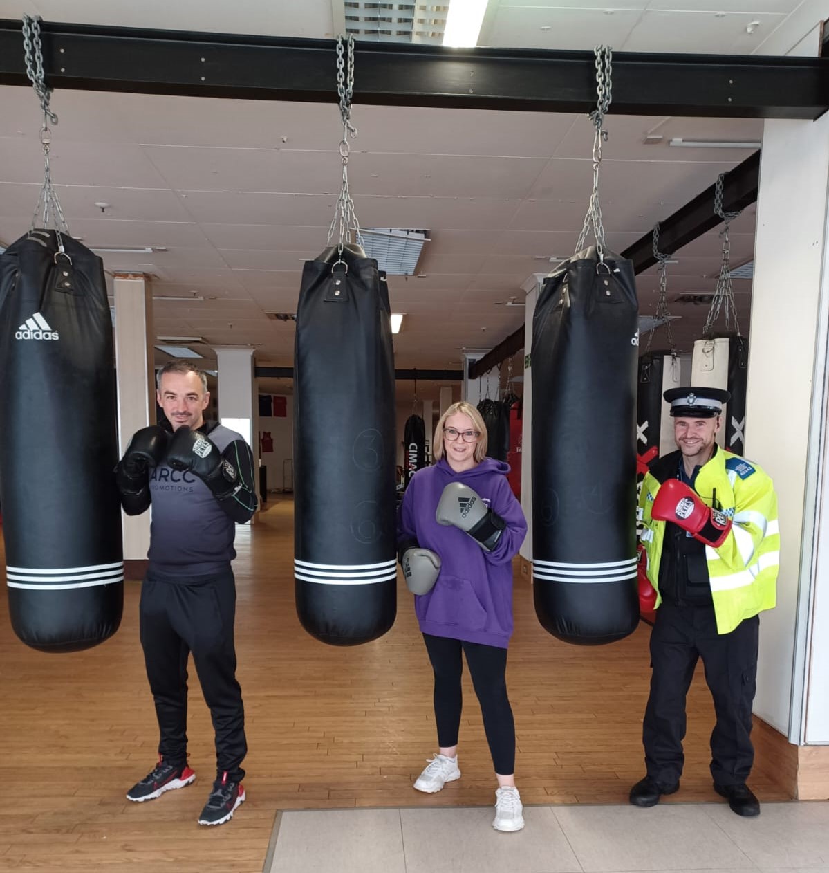 A PCSO and two people with punch bags