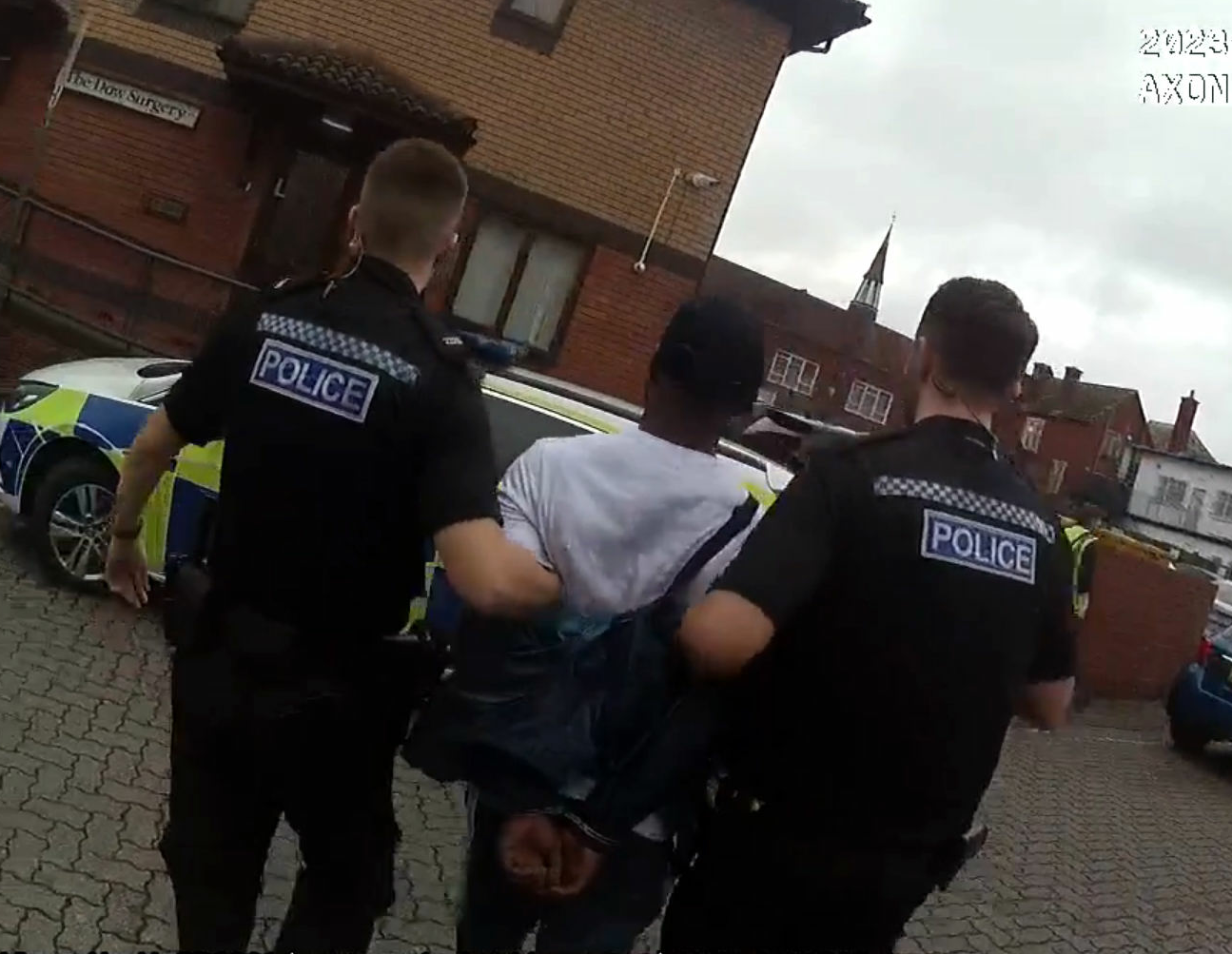 A man is led away by police officers