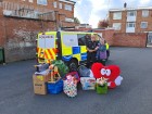 Police officer stood with lots of donated toys. 