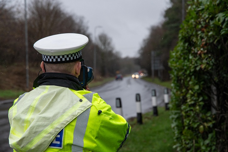 A police officer checks vehicle speeds