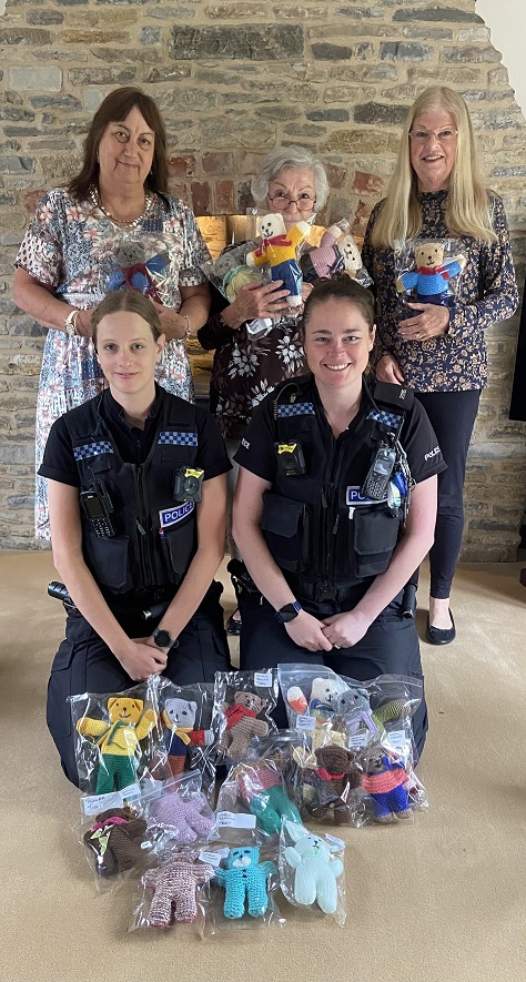 Officers and public holding teddy bears.