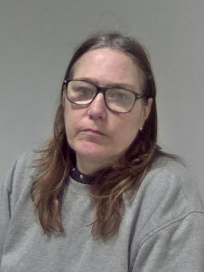 White female, long brown hair, glasses.