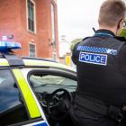 Police officer standing next to a police car