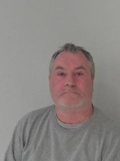 White male, grey hair, wearing grey top.
