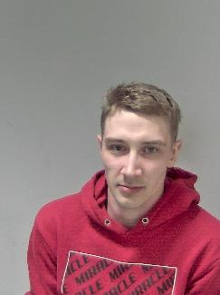 White male, brown hair, wearing red top. 