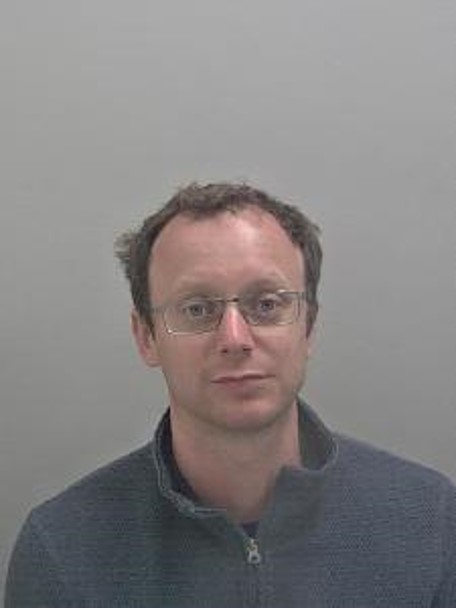 White male, brown hair with glasses. 