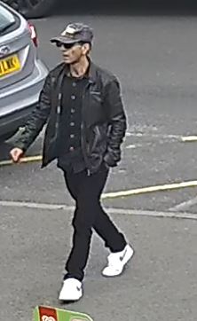 Man wearing grey baseball cap, black shirt and black jacket