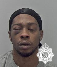 Black man with eyes closed, wearing a black head covering