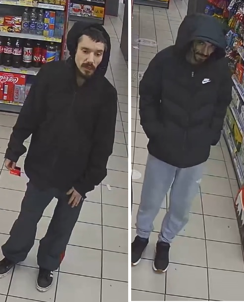 Two men wearing black coats with hoods up
