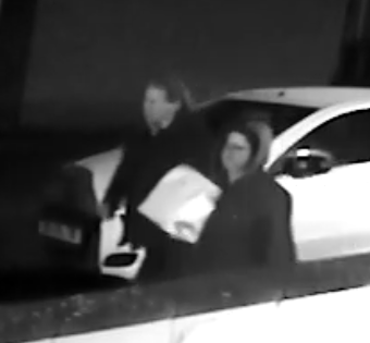 CCTV of two people standing by a white car