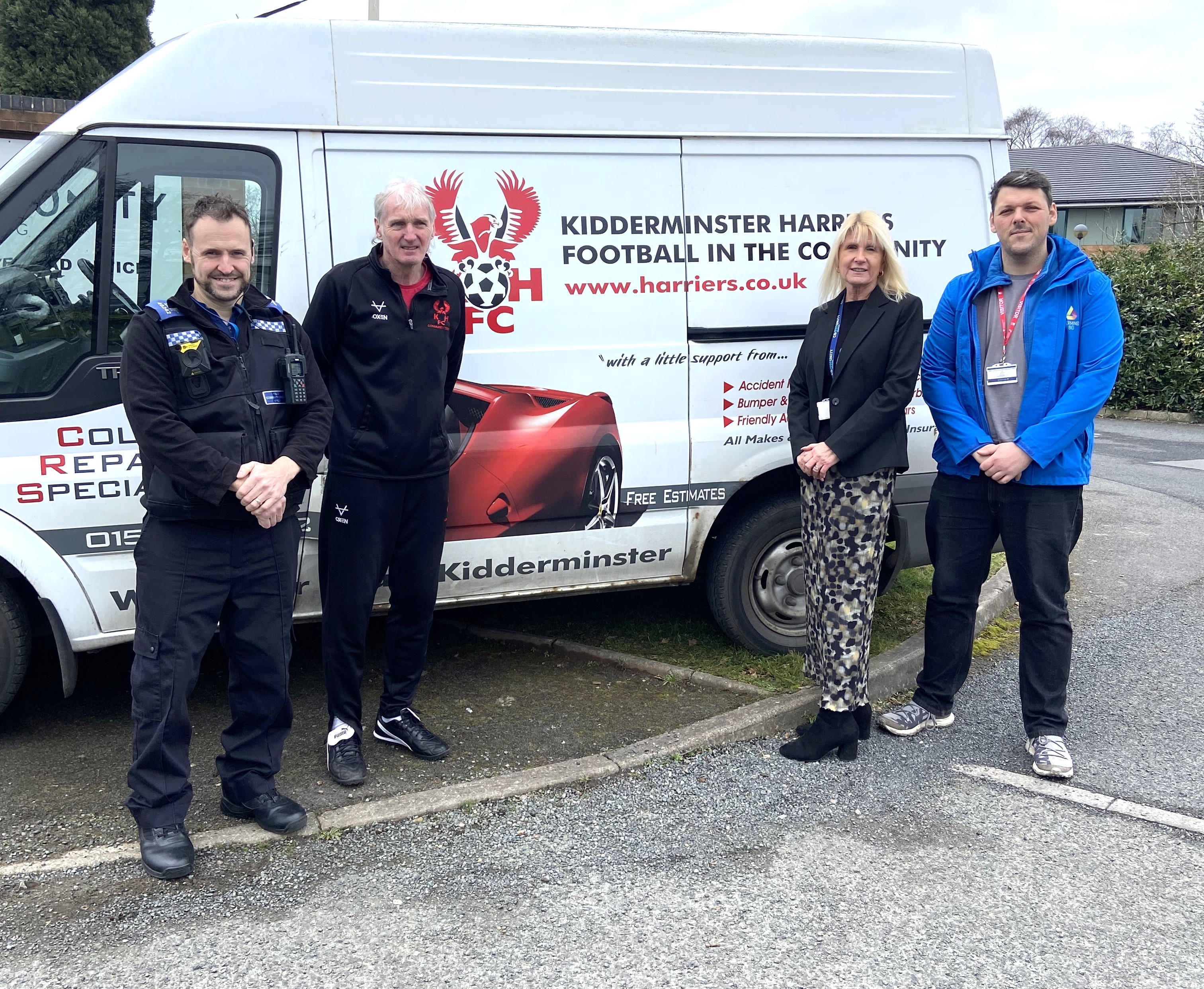 People stood next to Kidderminster Harriers van. 