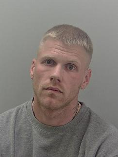 White male, blonde hair and wearing a grey t shirt. 