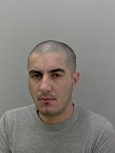 White male, shaved dark hair, grey t shirt. 