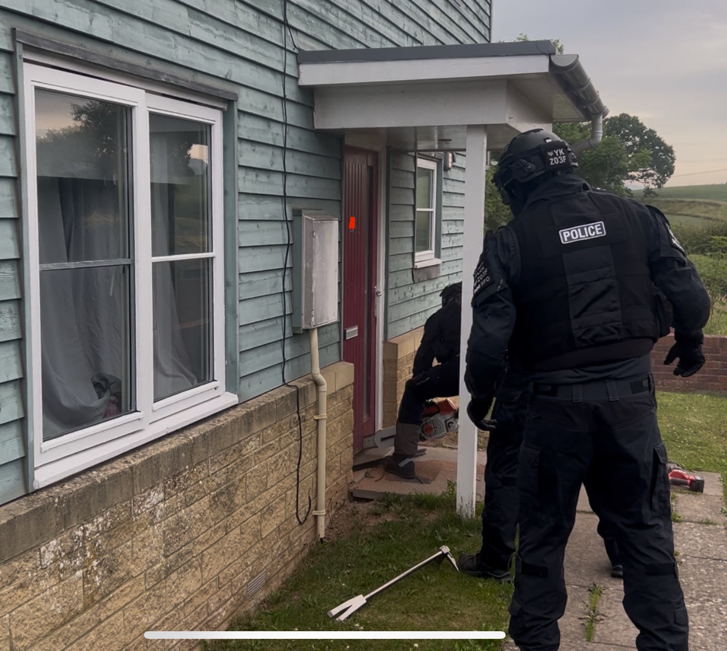 Officers entering a door.