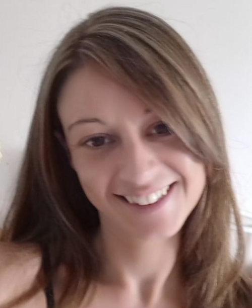 White woman with light brown hair, smiling