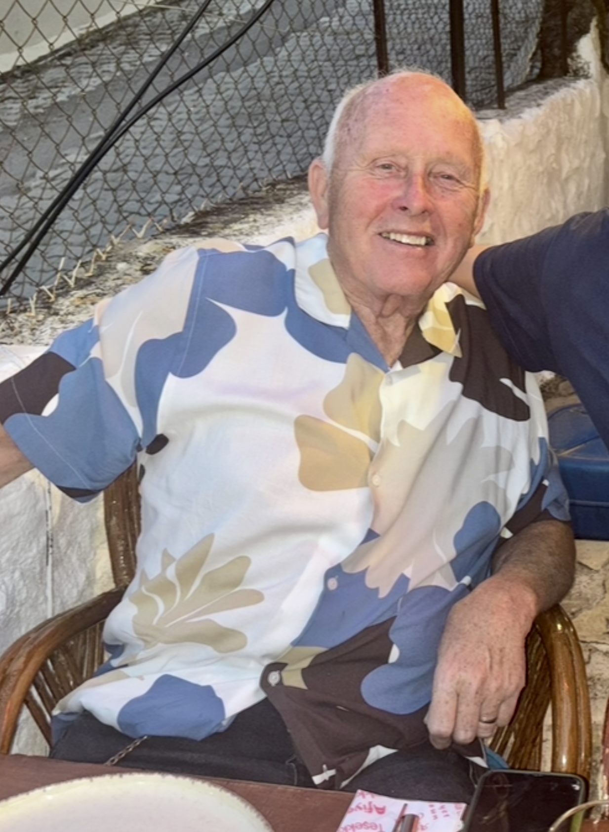 White male, floral shirt, smiling. 