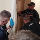 An officer using the red key to gain entry into a door