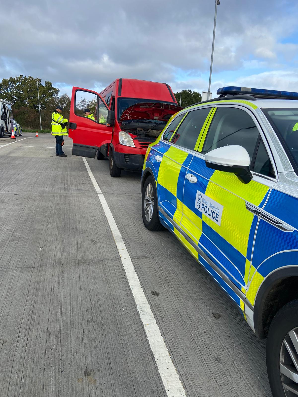 Red van parked behind a police car