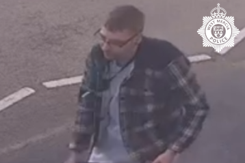 man with glasses wearing checked jacket 