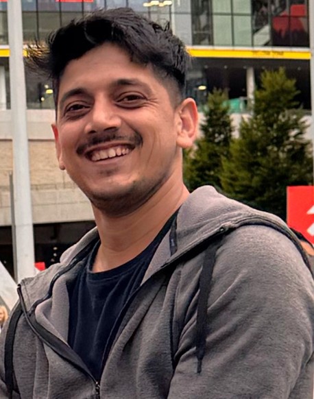 Asian man with dark, short hair and smiling. 