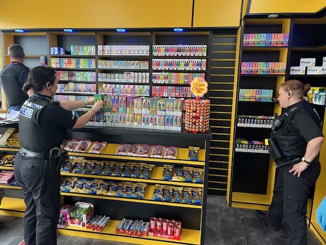 Three officers searching a vape shop