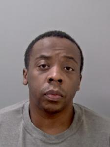 Black male, with short dark hair and grey t shirt. 