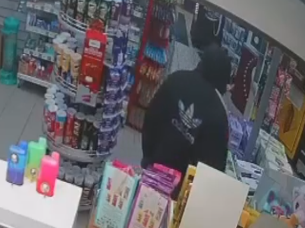Back of male wearing black hoodie with hood up. 
