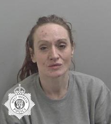 A woman with tied‑back hair wearing a grey sweatshirt sits against a plain grey background. A West Mercia Police badge logo appears in the lower-left corner of the image