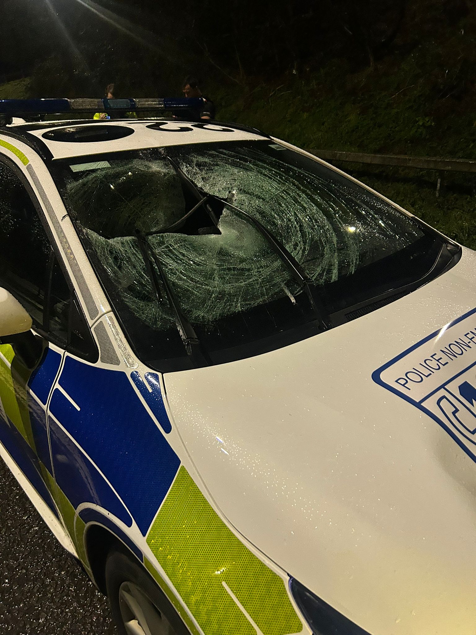 Police vehicle with smashed windscreen after wheelie bin was thrown at it