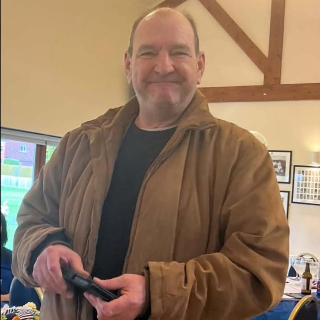 man in his 60s with balding head smiling for photo
