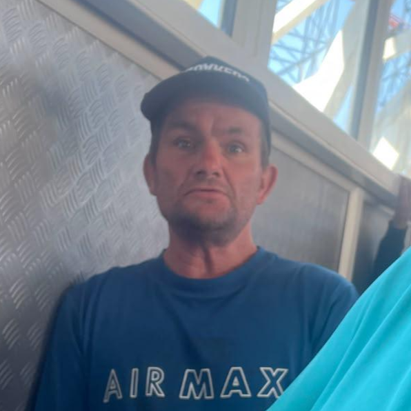 man in his 40s wearing blue airmax t-shirt and baseball cap