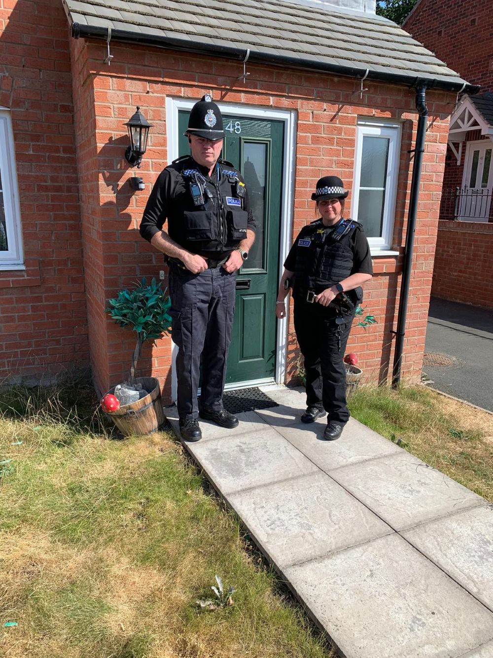 Two officers stood outside 48 Wray Drive in Pontesbury