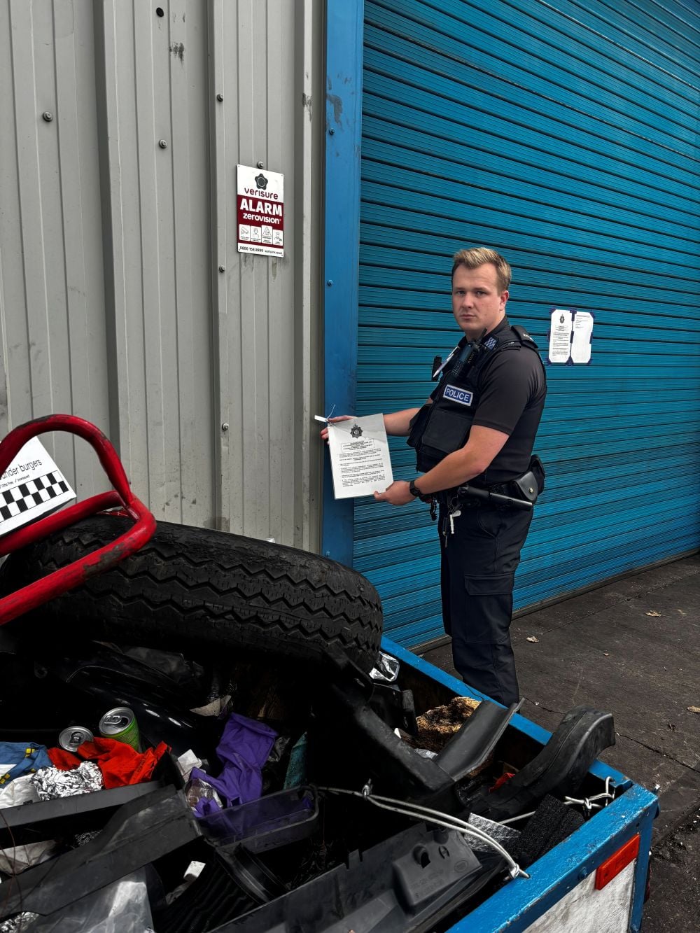 PC Dan Arthur with the closure notice pinned to a shutter