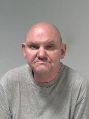 White male, no hair, wearing grey t shirt