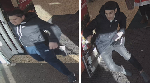 two men in dark hoodies leaving a shop